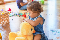 Adorable toddlers smiling happy. Sitting on the floor playing around lots of toys at kindergarten